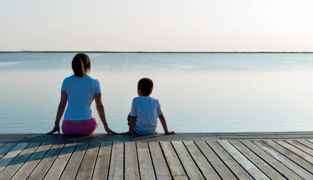 Mother with her son enjoying lake view.