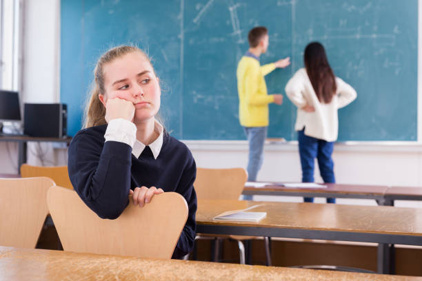 istock Unhappy girl sitting in class 1245979917