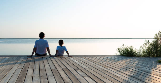 istock Father with his son enjoying lake view 1245981213
