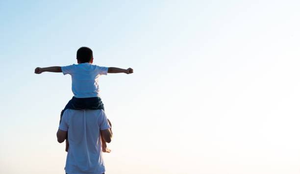 istock Father carrying his son on shoulders 1245981222