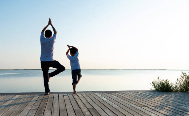 istock Father with his son doing yoga by the lake 1245982513