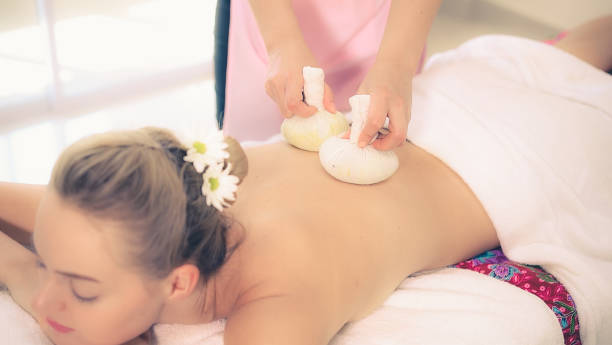 istock Massage therapist using herbal compress with woman 1245986372