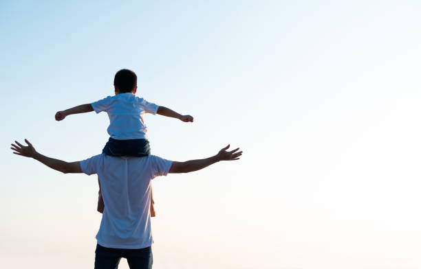 istock Father carrying his son on shoulders 1245986967