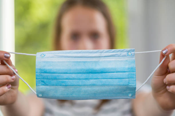 istock Girl holding protective face mask 1246005408