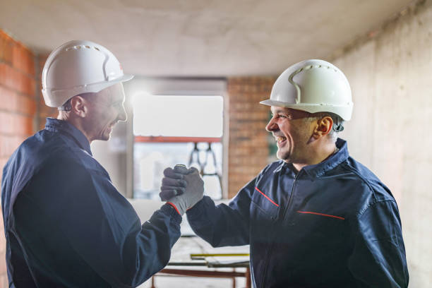 istock Cheerful manual workers greeting each other at construction site. 1246016267