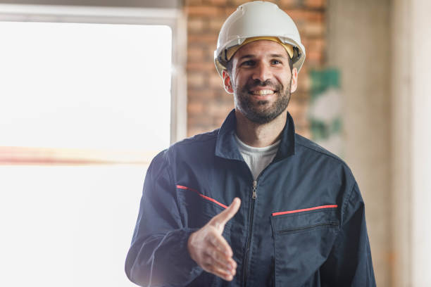 istock Happy manual worker offering a handshake at construction site. 1246017349