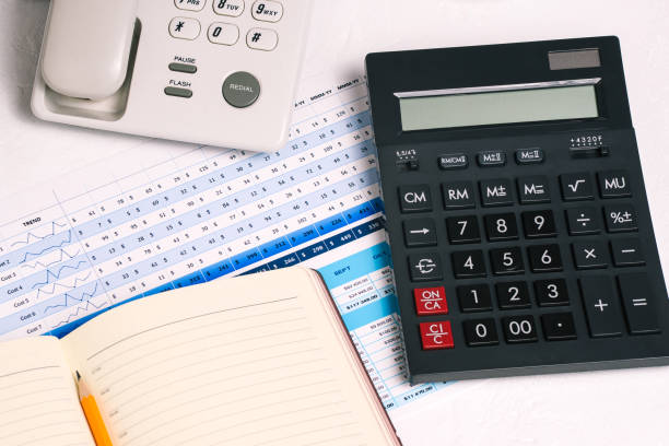 istock A work Desk with a telephone, a calculator and a notebook. Financial graph for the company sales report and analysis. 1246019032