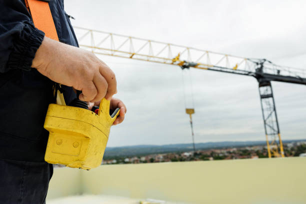 Close up of unrecognizable crane operator using control panel while working outdoors.