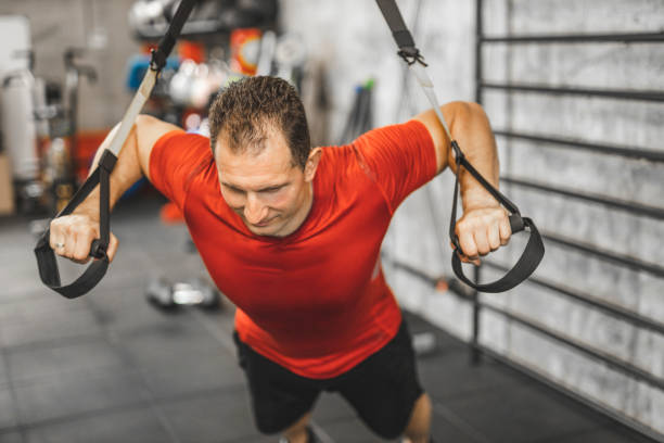 istock Man performing training in gym. Muscular guy doing exercise with elastic rope 1246024984