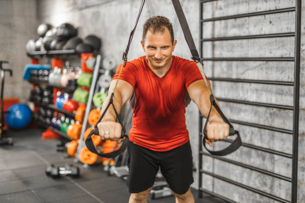 istock Man performing training in gym. Muscular guy doing exercise with elastic rope 1246026656