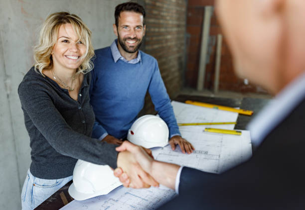 istock Happy couple closed a deal with architect at construction site. 1246029049