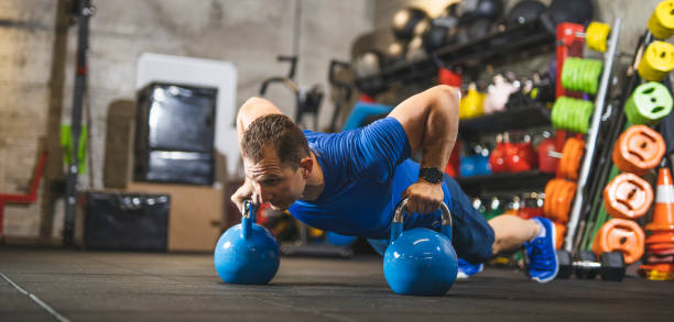 istock Determined athlete doing push-ups on kettlebells in gym 1246029193