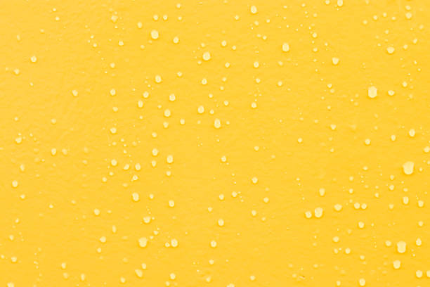 istock Blue water drops on yellow wooden background. 1246030879