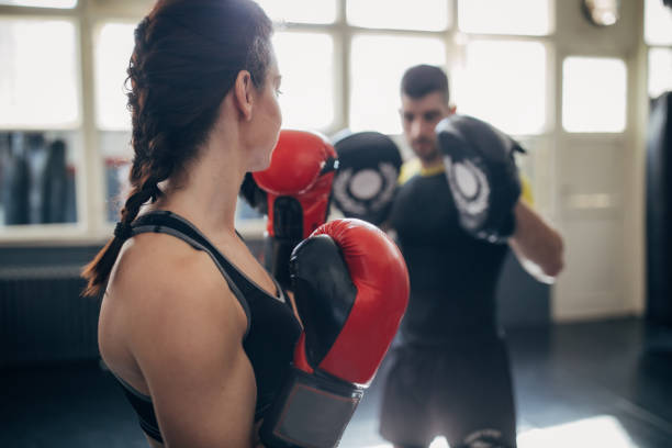 istock Female boxer training with her male coach in gym 1246030893