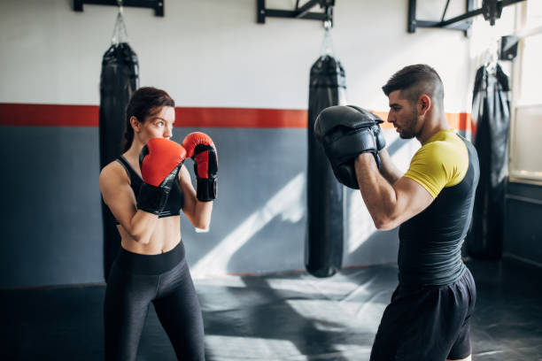 istock Female boxer training with her male coach in gym 1246031452