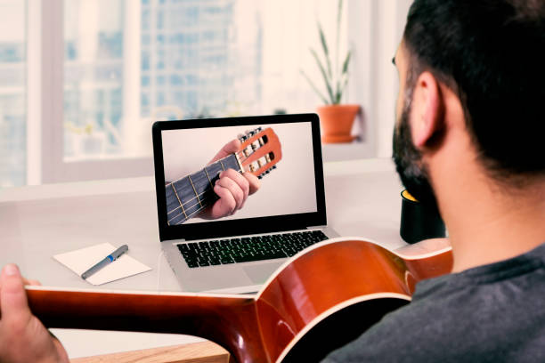 istock caucasian man learning to acoustic guitar with video lessons 1246054390