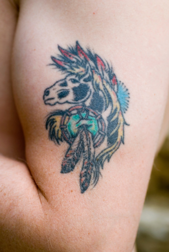 Apache horse tattoo on mans arm.