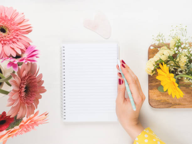 istock White open notebook and pen in female hand 1246106069