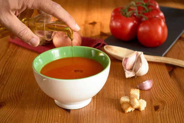 istock Tomato Gazpacho Cook Onion Garlic Spoon Toasted Bread selective focus hand oil 1246112180