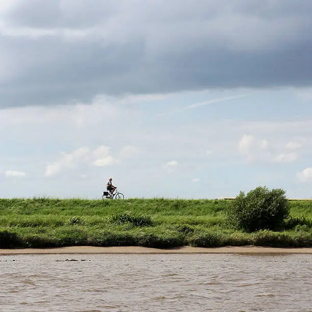 man cycling trough the Dutch landscape.