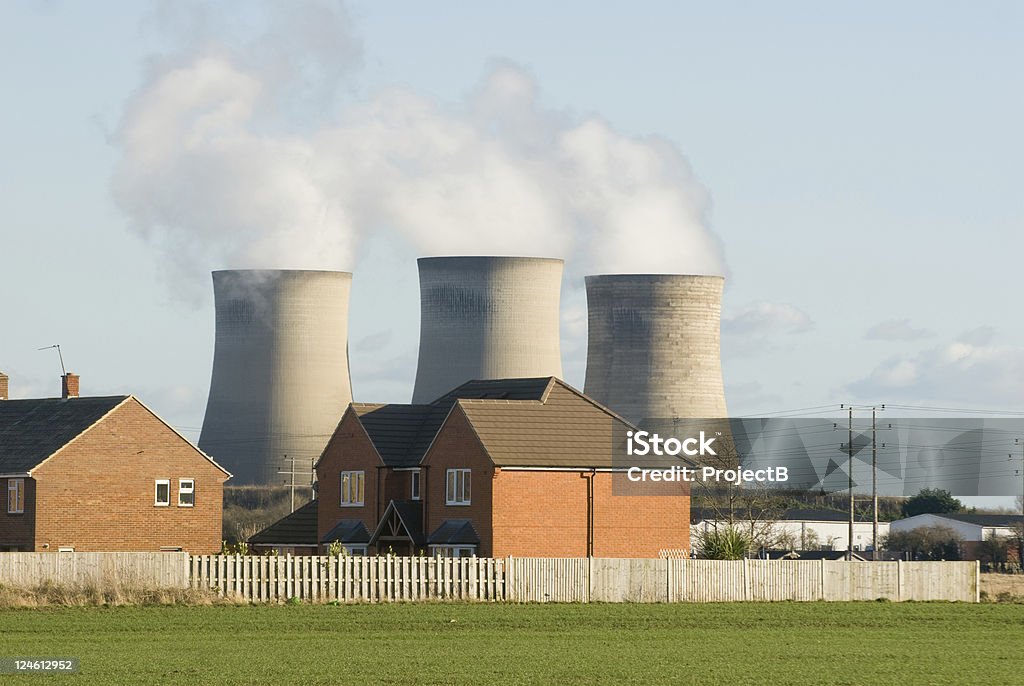 Power Station near homes housing estate with chimneys in the background. Air Pollution Stock Photo