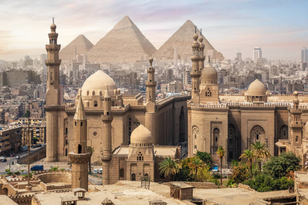 The Mosque of Sultan Hassan and the Great Pyramids of Giza, Cairo skyline, Egypt The Mosque of Sultan Hassan and the Great Pyramids of Giza, Cairo skyline, Egypt. egypt skyline stock pictures, royalty-free photos & images