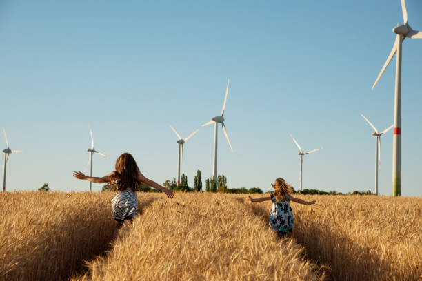 mädchen laufen der weg zur windenergie - fuel and power generation power wind power supply stock-fotos und bilder