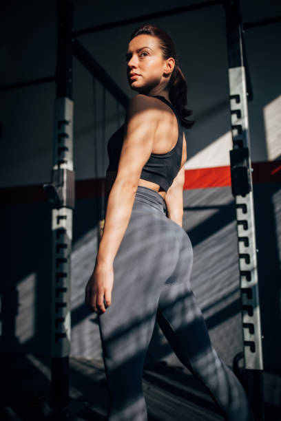 istock Fit young woman standing alone in dark gym 1246135983