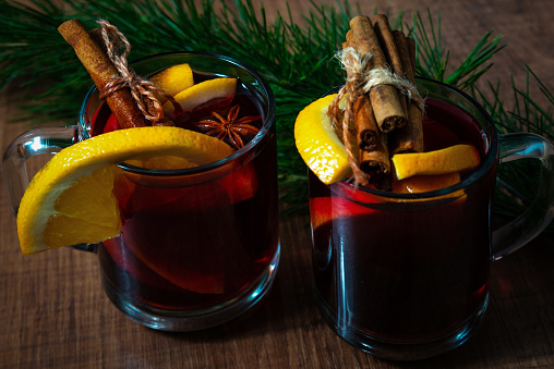 Fragrant hot mulled wine in glass mugs on a Christmas holiday background.