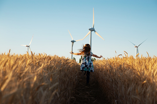 Girl is running the way to wind energy