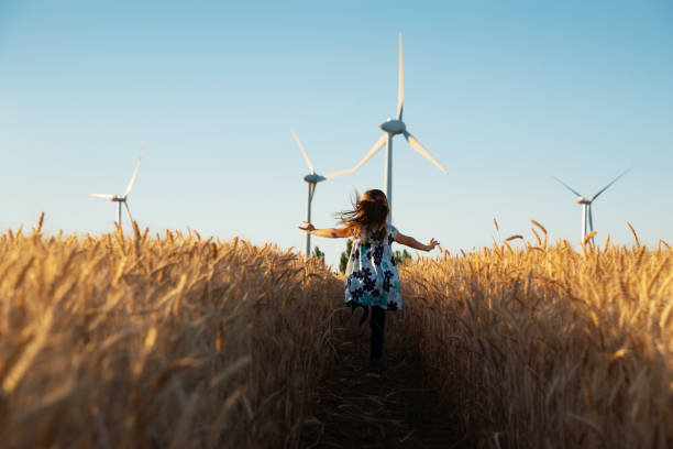 Girl is running the way to wind energy Girl is running the way to wind energy sustainable energy stock pictures, royalty-free photos & images