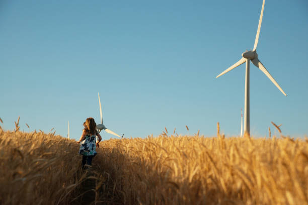 mädchen läuft den weg zur windenergie - fuel and power generation power wind power supply stock-fotos und bilder