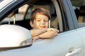 Cute little boy looking out of the car enjoying road trip