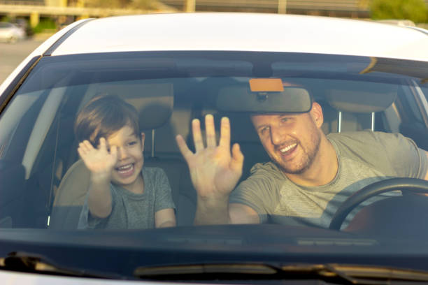 istock Father and son putting their hands on the front window in car. 1246153876