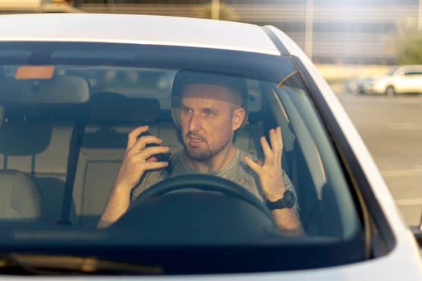 istock Angry man driving his car and talking on mobile. 1246153887