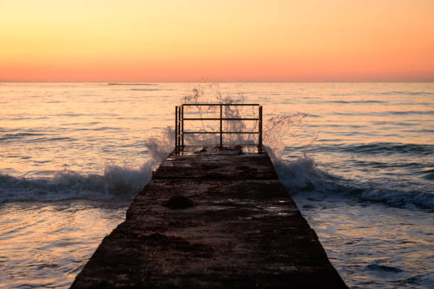 Old pier with waves at sunset in Paphos, Cyprus