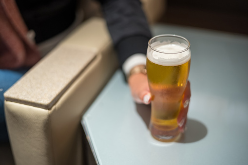 Asian woman hand holding chilled beer in lounge