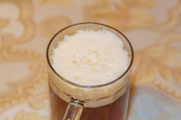 Thick beer foam and a filled glass mug