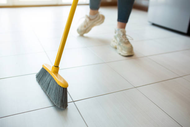 young woman on kitchen during quarantine. low cut view of girl in sneakers sweep the floor alone. house holding in kitchen. daylight. - clear sky built structure apartment sky imagens e fotografias de stock