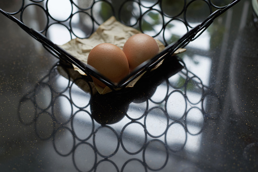 egg in the wire basket with green plant reflection as background