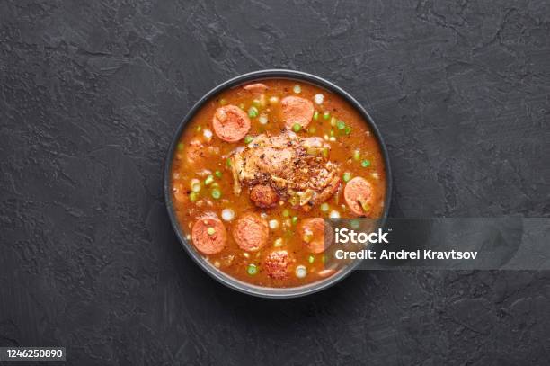 Chicken And Sausage Gumbo Soup In Black Bowl On Dark Slate Backdrop Gumbo Is Louisiana Cajun Cuisine Soup With Roux Stock Photo - Download Image Now