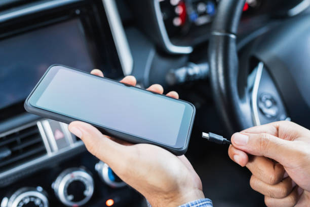 istock Hands man holding and charging battery mobile smartphone in car with cable in luxury interior car design. 1246292563
