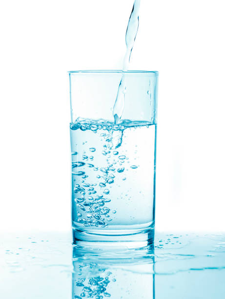 istock Pouring water into glass in blue toning 1246316515