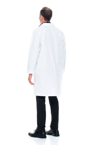 giovane medico caucasico in piedi di fronte a uno sfondo bianco indossando un camice da laboratorio - brown hair isolated on white short hair young men foto e immagini stock