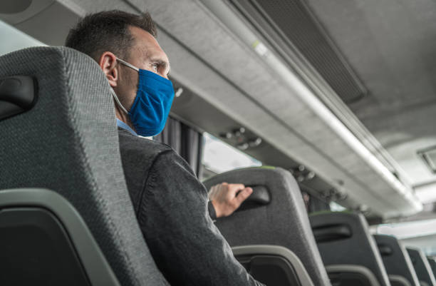 Men in Safety Breathing Mask on His Face Traveling Alone in a Bus Coach Men in Safety Breathing Mask on His Face Traveling Alone in a Bus Coach. Public Transportation During Pandemia. Safety Measures in Public Places. intercity train photos stock pictures, royalty-free photos & images