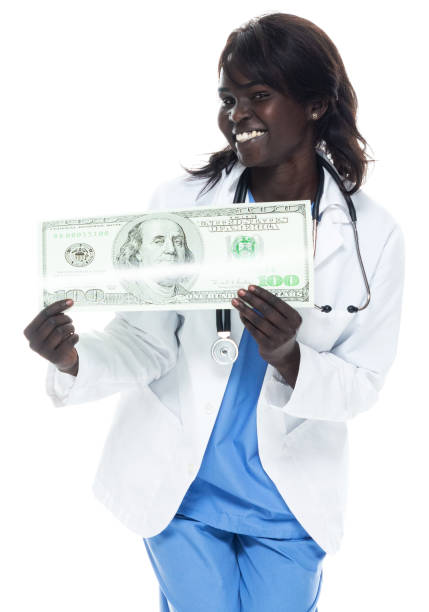 médecin africain d’ethnicité de jeunes femmes restant devant le manteau blanc de laboratoire de fond et nous retenant la monnaie - laughing women us paper currency isolated photos et images de collection