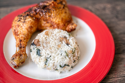 White rice with roasted chicken drumstick in plate