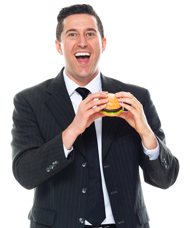 african american man in white t-shirt bites big burger and rejoices on yellow isolated background, young guy eats fast food and rejoices, close-up