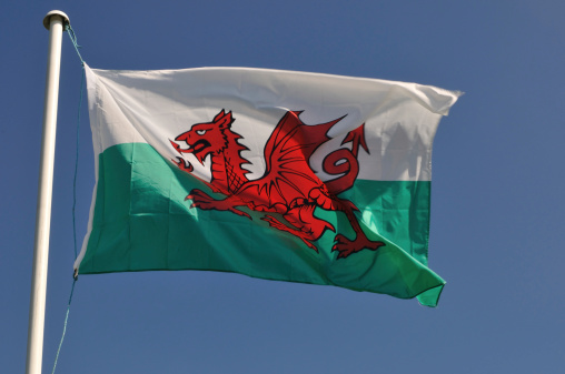 The British Union Jack and the Welsh flag fly proudly togetheragainst a blue summer sky