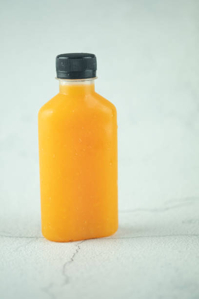 istock Orange juice bottled (healthy drink) on cement white background 1246341142